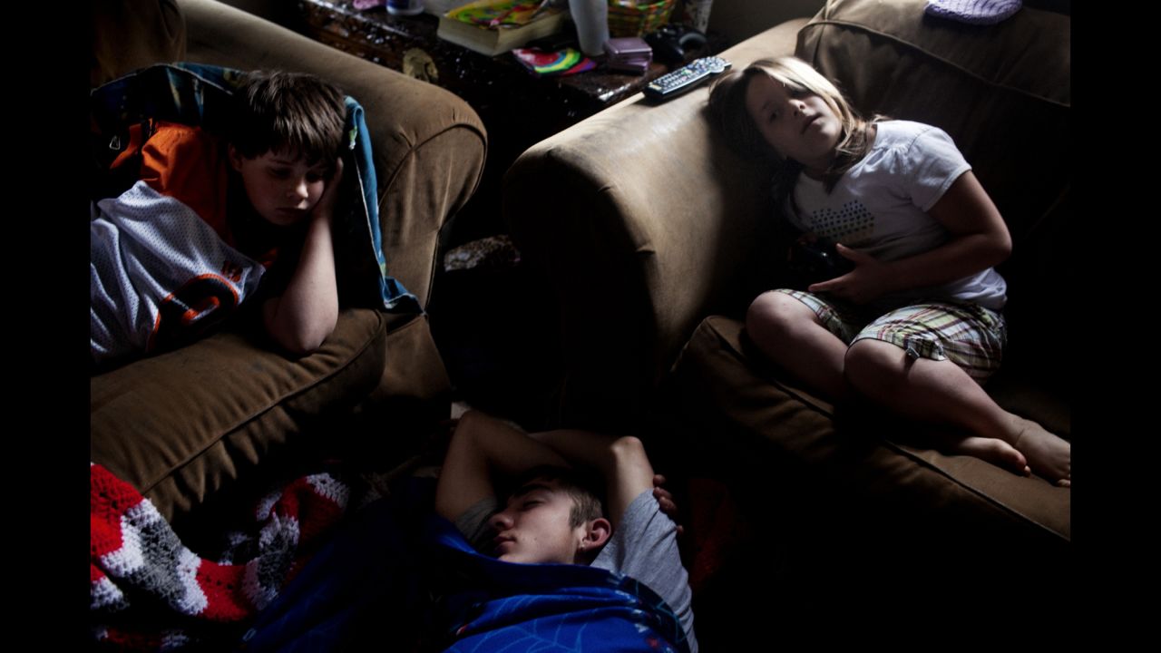 William Sellers, left, and one of his sisters lie on a sofa as their visiting cousin, Dominic, sleeps on their floor in Columbus, Ohio, in 2010. The family moved from Chauncey to Columbus so the twins could attend a school for deaf children.