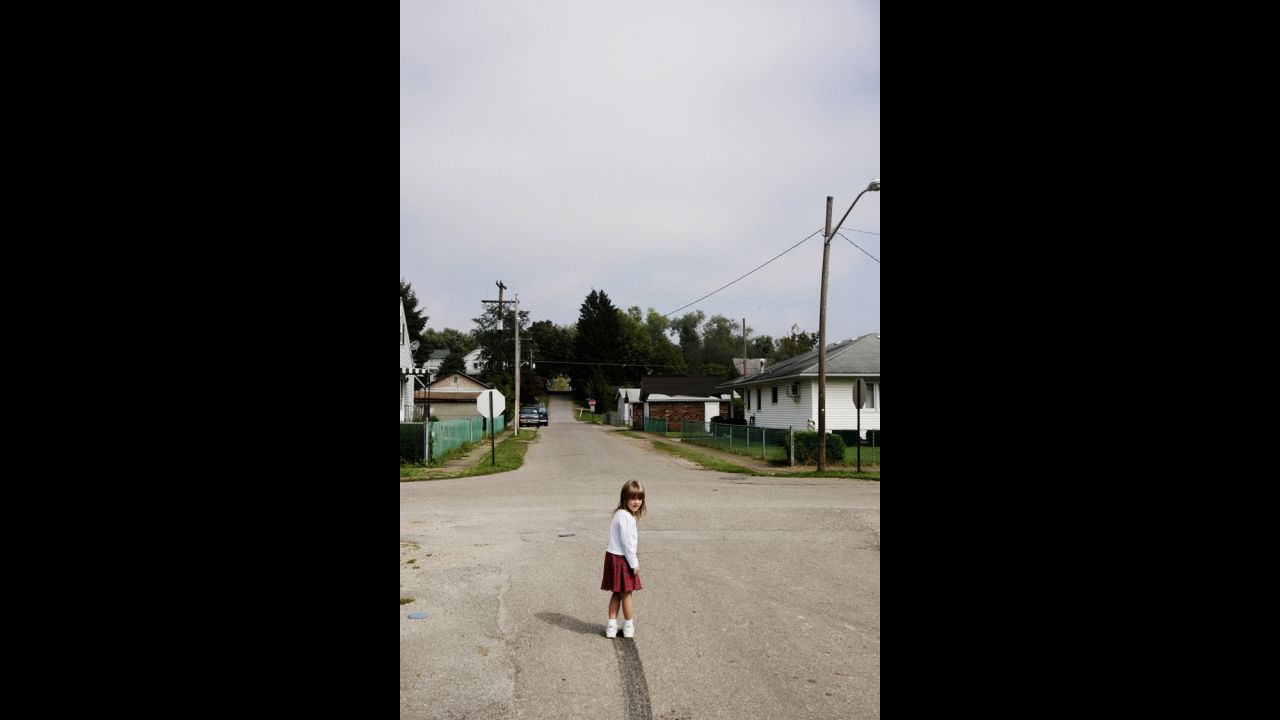 Lacey wanders out in the middle of the street to examine the skidmark her dad left as he drove away one day. At the time, Eich said, he couldn't put his finger on what struck him about the photo. The realization came later, when the photographer had children of his own. "In the photo, there's some uncertainty to the road; you can't really see where it leads. It makes me think of the opportunities my daughters have, compared to those that the twins have."