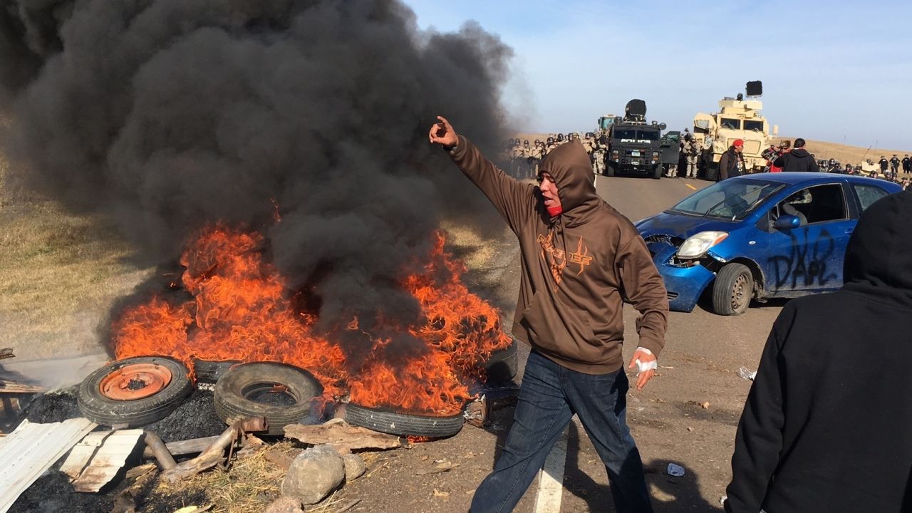 Demonstrators stand near burning tires as they face off with law enforcement Thursday.