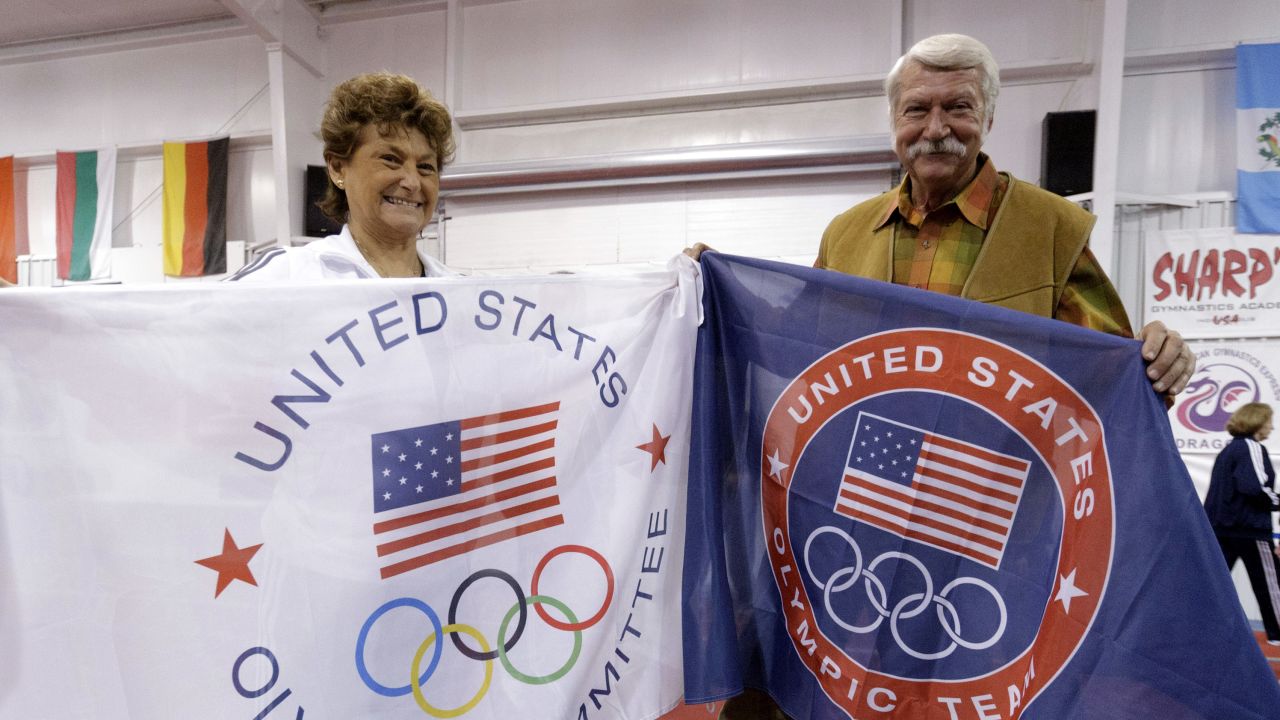 Martha and Bela Karolyi display banners after Karolyi Ranch was named an official Olympic training site for USA Gymnastics.
