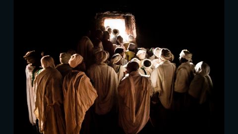 Pilgrims waiting to emerge from inside a tunnel at Bet Girogis or the House of St George, Lalibela, Ethiopia. This hand-carved, 12th century church is connected to 12 other churches by a series of tunnels, designed to protect medieval worshipers from attacks, but also to symbolize the movement of pilgrims from darkness to light.