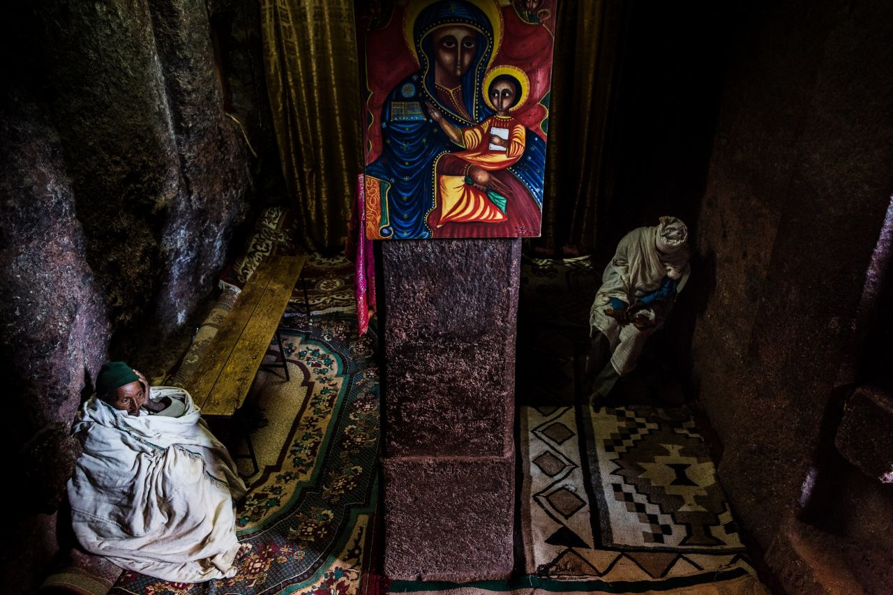 In a prayer room at the House of St George, Lalibela, two priests wait for the day's pilgrims to arrive. Up to 100,000 worshipers travel to these medieval hand-carved churches during times of celebration, to be blessed by the priests and to touch and kiss the sacred walls. 