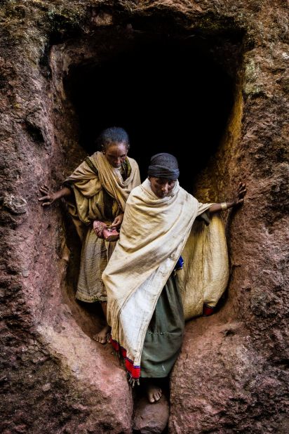 Two pilgrims emerge from a tunnel in one of Lalibela's stone churches.