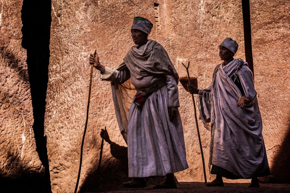In Lalibela life feels largely untouched by the centuries. Two nuns, wrapped in devotional white robes and carrying prayer staffs.