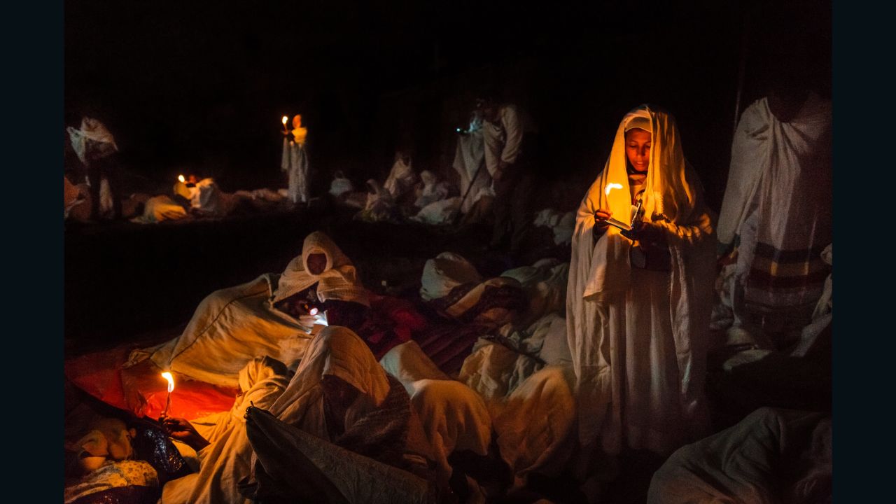 A group of pilgrims pray and read their bibles by candlelight around the churches of Lalibela.