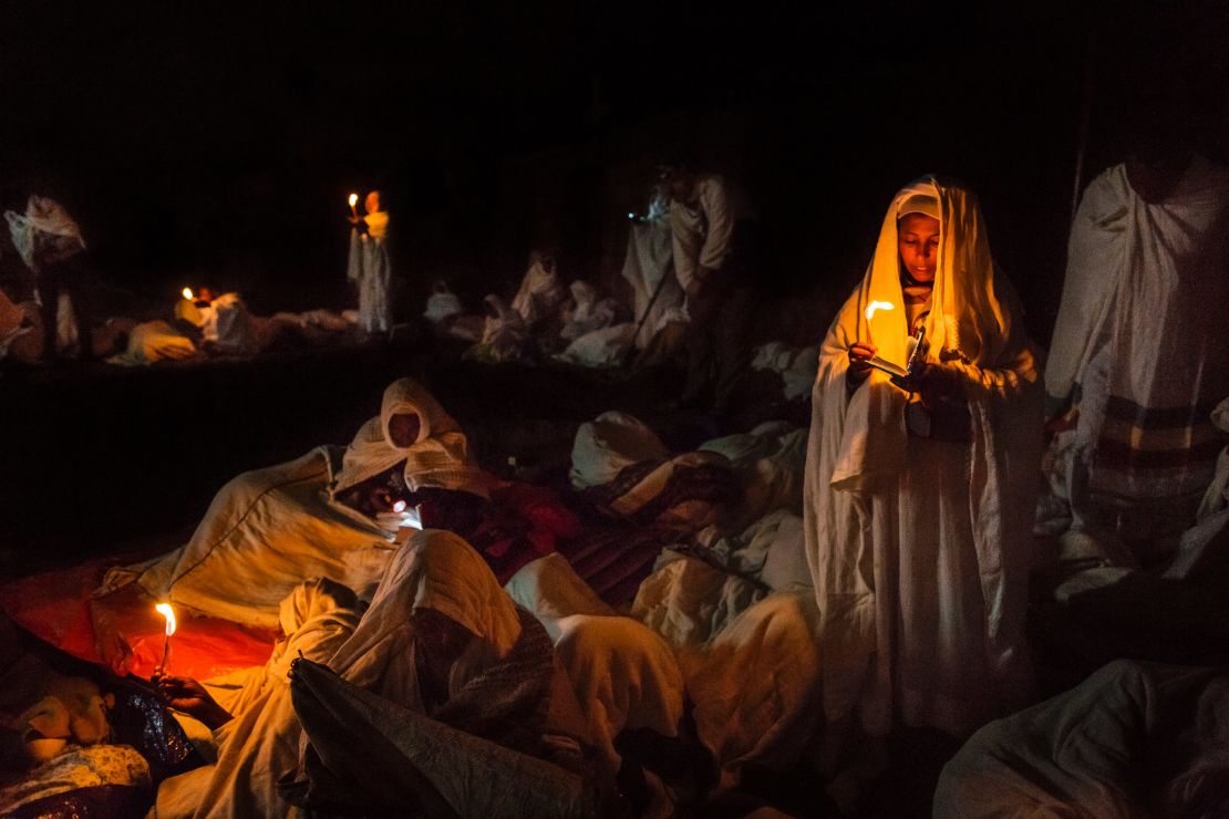 A group of pilgrims pray and read their bibles by candlelight around the churches of Lalibela.