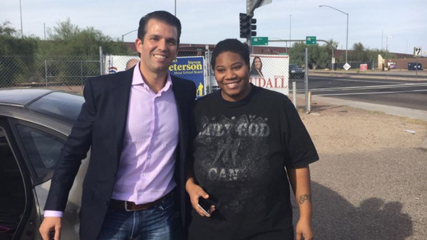 Donald Trump Jr. poses with a woman after he helps push her stalled car in Mesa, Arizona