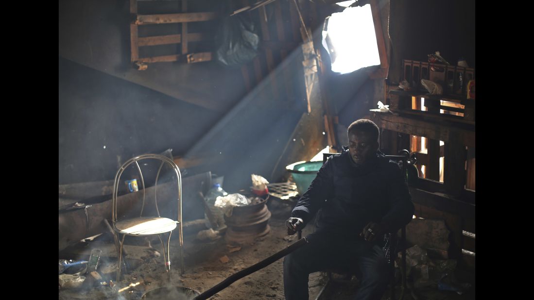 A migrant man sits inside a shack that remains in the otherwise demolished Jungle camp on October 27. French authorities said Wednesday that almost 5,600 migrants had been bused to relocation centers around France.