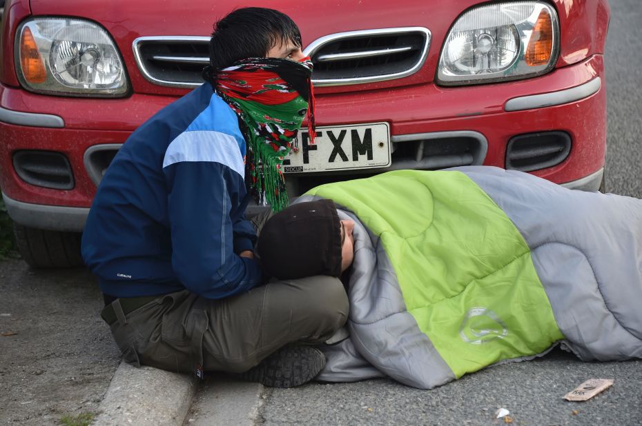 Two migrants rest near the Jungle site on October 27. Long lines for processing have been cited as the reason some didn't manage to register earlier in the week.