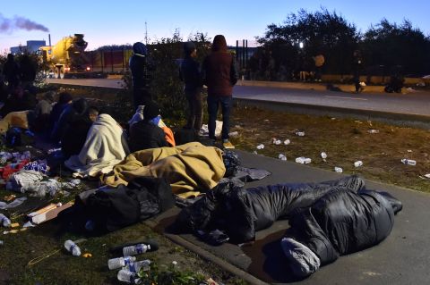 A group of migrants who slept outside an aid station near the Jungle wait to be assigned relocation to processing centers across France on October 27.