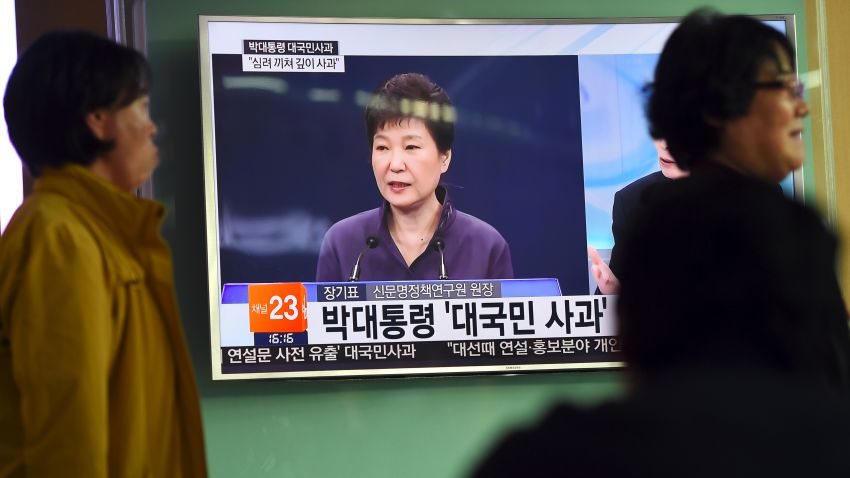 People walk past a television screen showing South Korean President Park Geun-Hye making a public apology, at a railway station in Seoul on October 25, 2016.
South Korean President Park Geun-Hye was forced into a public apology on October 25 for the leak of official documents to a family associate involved in a growing corruption scandal. / AFP / JUNG YEON-JE        (Photo credit should read JUNG YEON-JE/AFP/Getty Images)