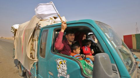 An Iraqi man waves a white flag as his family flees the fighting Thursday.