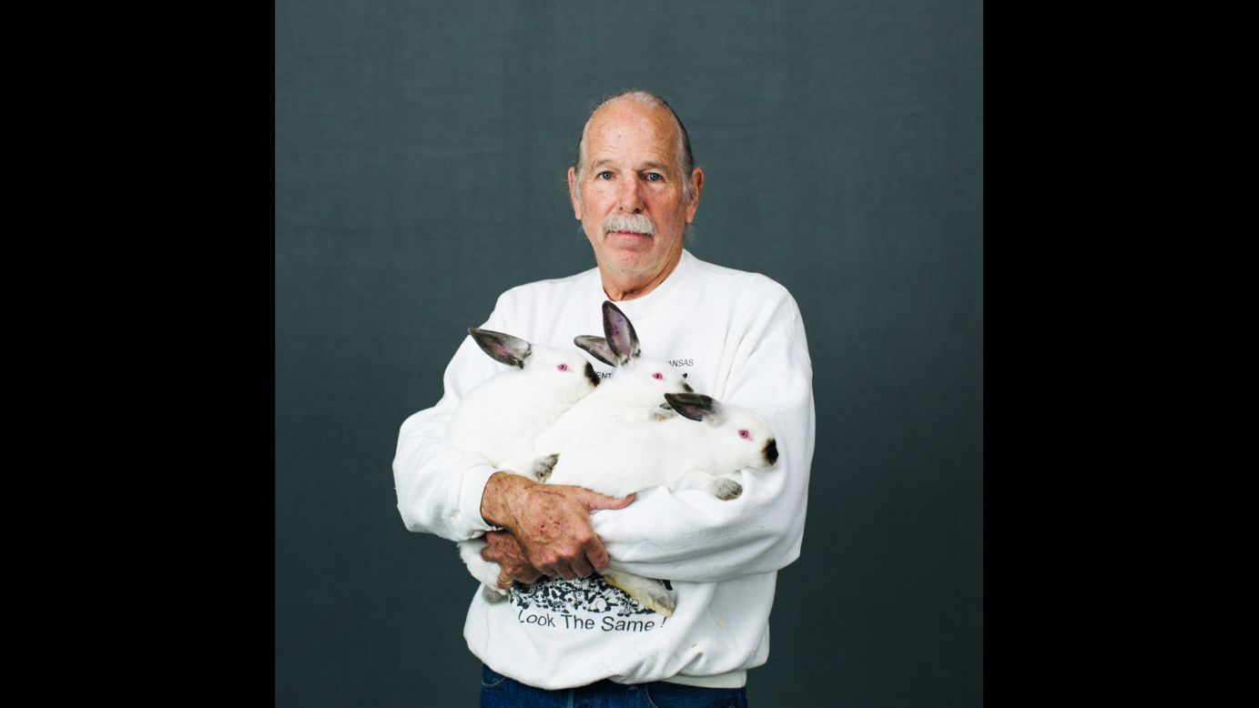 Rob Fender, a breeder from Julian, California, holds three Californian rabbits. He names all of his rabbits with numbers.