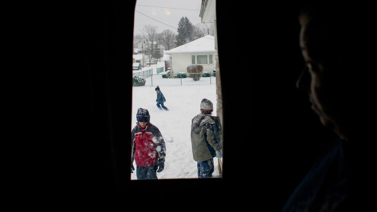 Tracy Sellers watches her kids play with neighbors in the front yard of their home in Chauncey, Ohio, in 2007. Chauncey's coal-mining corporations fled, leaving the community impoverished and "brokenhearted," according to Eich.