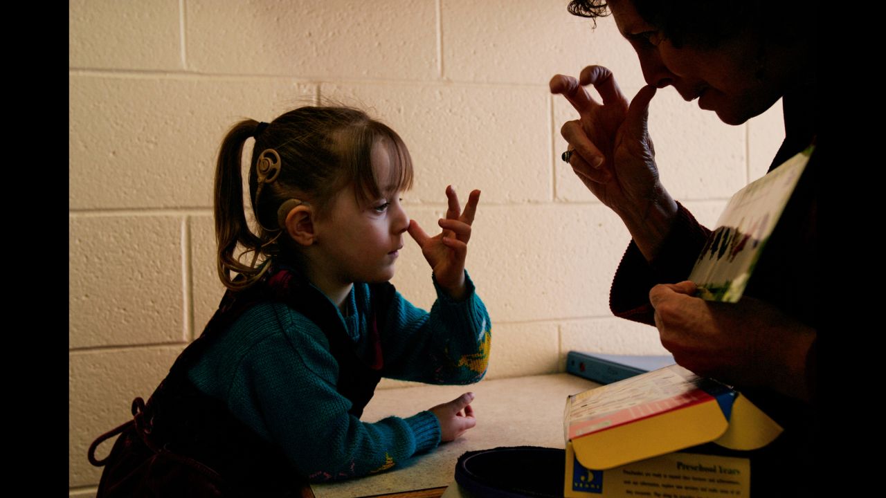 School therapist Pattie O'Brien makes the sign for "bug" with Lacey during one-on-one-tutoring in 2006.