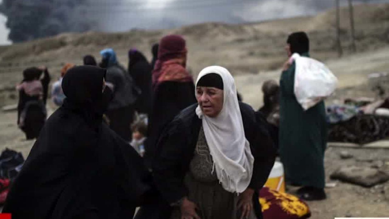 Displaced Iraqi families gather near Qayyarah on Friday.
