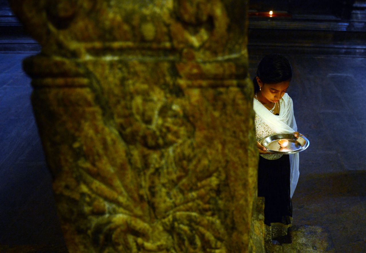 A Sri Lankan Hindu holds an oil lamp while offering prayers at a temple in Colombo on October 29.