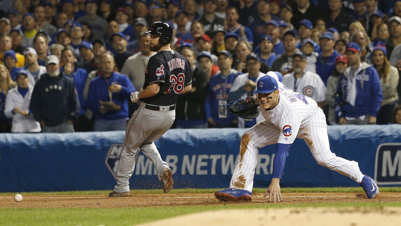 Cleveland's Corey Kluber is safe at first as Cubs first baseman Anthony Rizzo can't make a play on a wild throw by third baseman Kris Bryant during the second inning of Game 4.