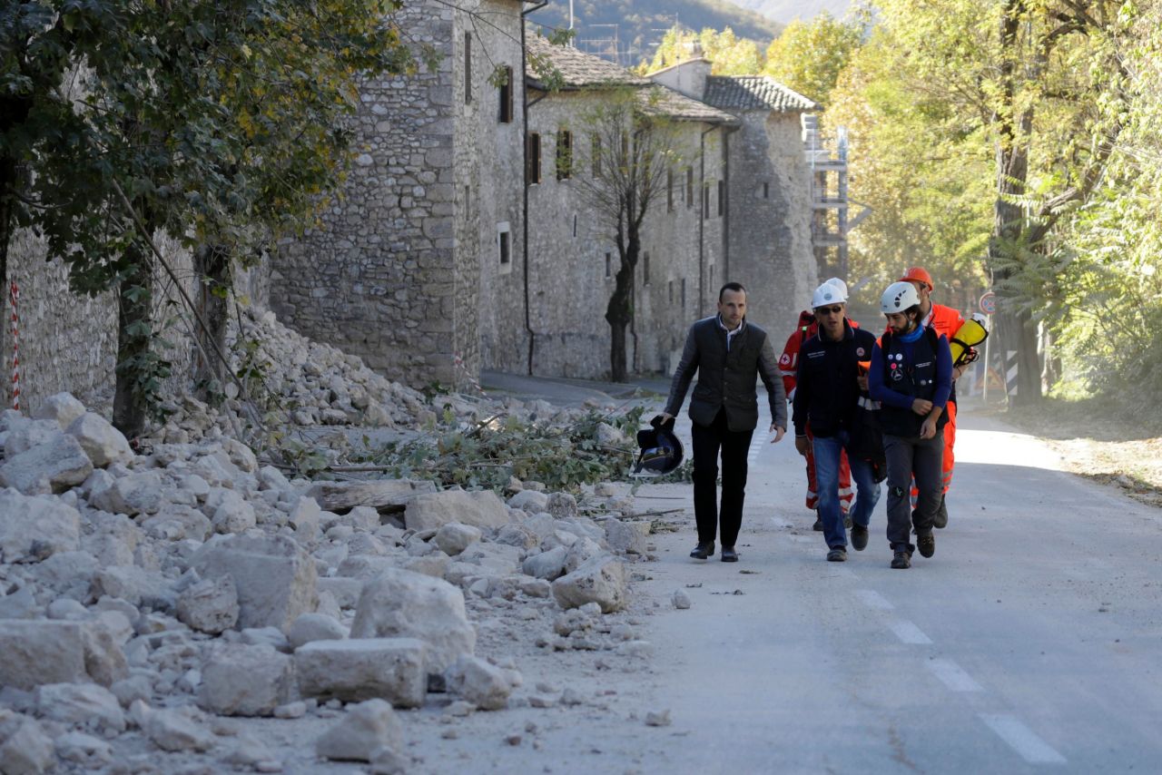 Italian civil protection personnel pass a collapsed wall in Norcia on October 30.