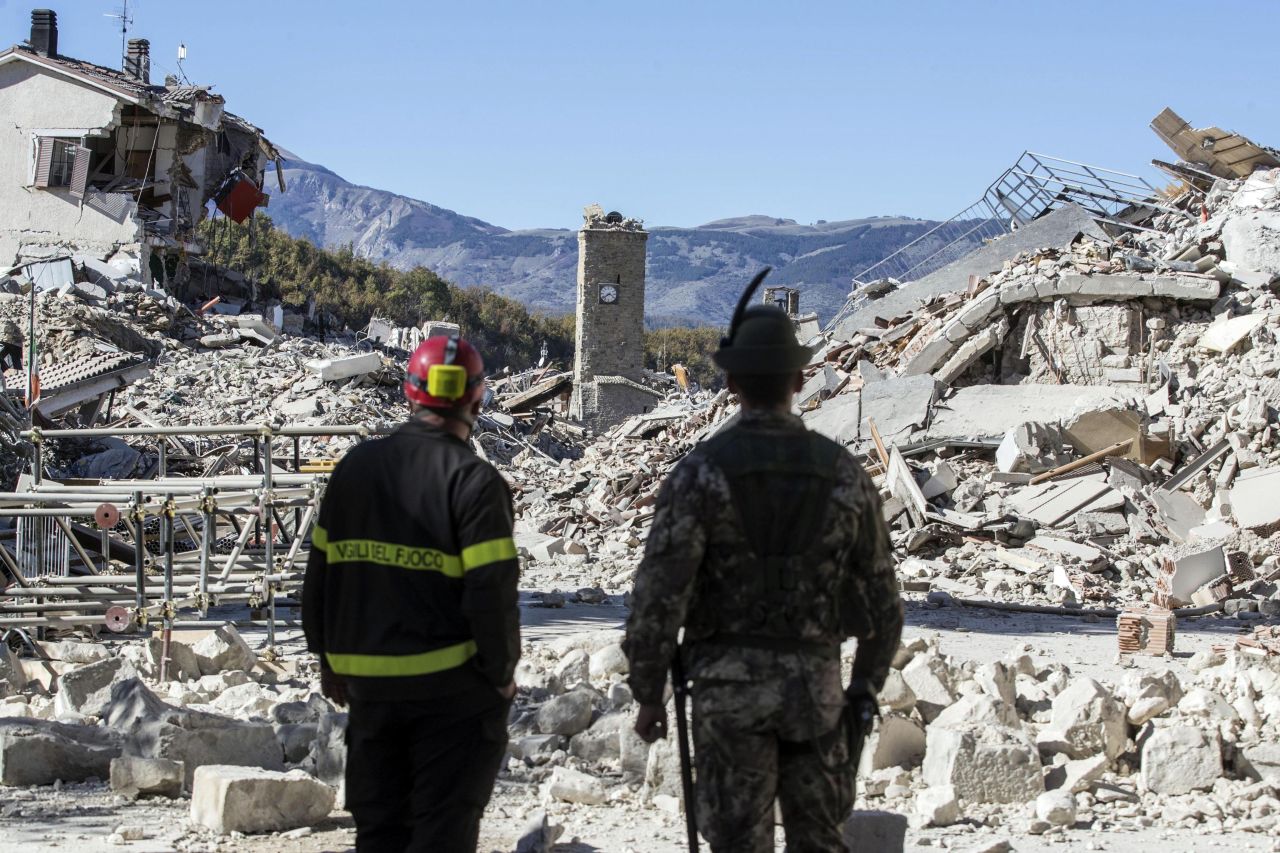 A firefighter and a soldier survey rubble in Amatrice on October 30. The latest quake on Sunday was the strongest to hit the country in more than three decades. Two other quakes struck the same region within the past week. Amatrice's town center also was badly damaged in a deadly temblor in August.