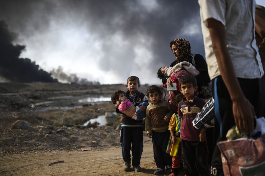 Displaced families are seen on the road near Qayyara on Saturday, October 29.