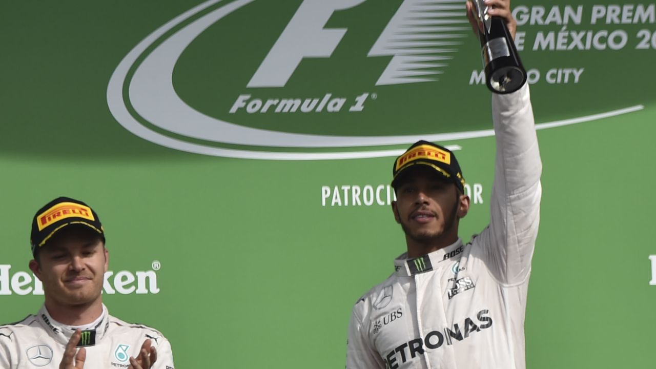 Lewis Hamilton raises the trophy after beating Mercedes teammate Nico Rosberg into second place in the Mexican Grand Prix. 