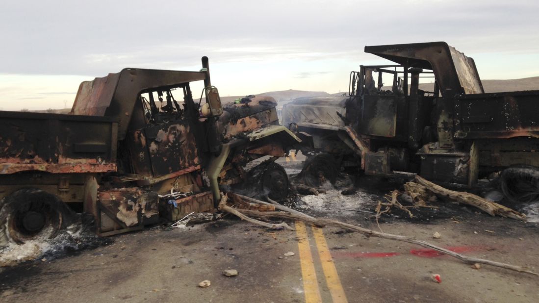 The burned hulks of heavy trucks sit on Highway 1806 on Friday, October 28, near a spot where Dakota Access Pipeline protesters were evicted a day earlier.