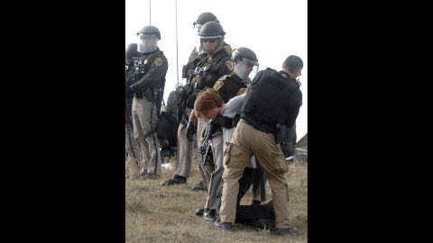 A protester is arrested as law enforcement surrounds the camp on October 27. 