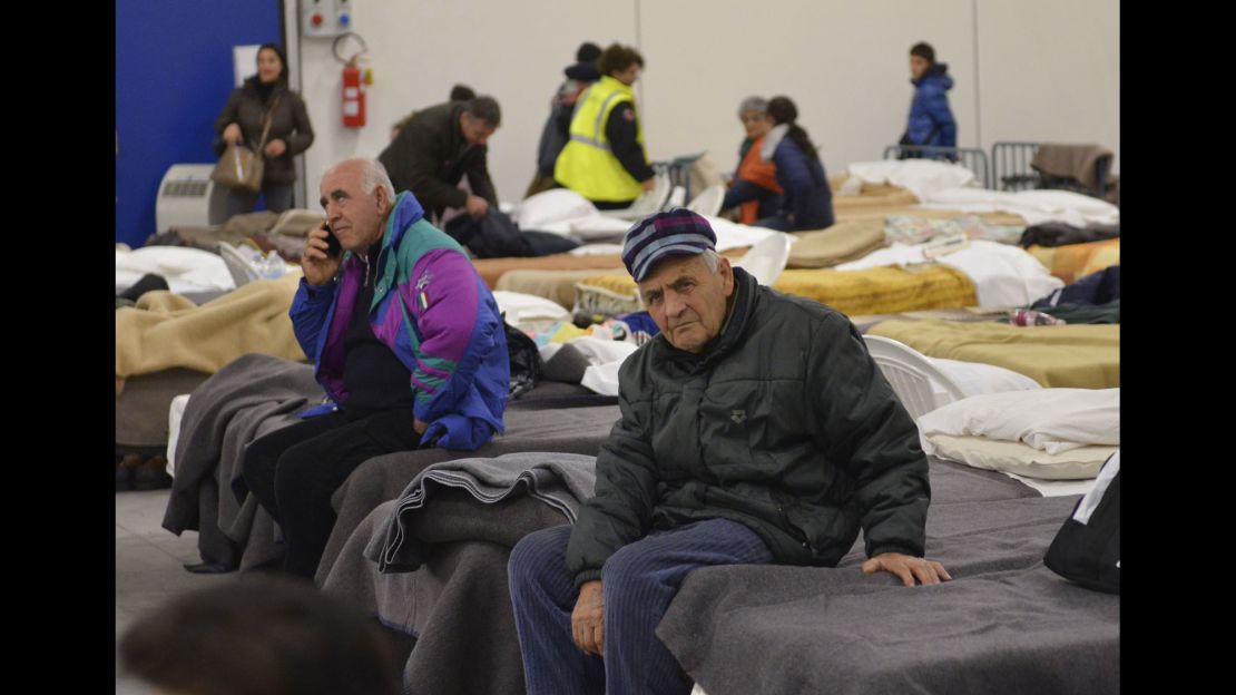 Residents prepare to spend the night in a camp set up in a warehouse in the village of Caldarola on Sunday following the quake.