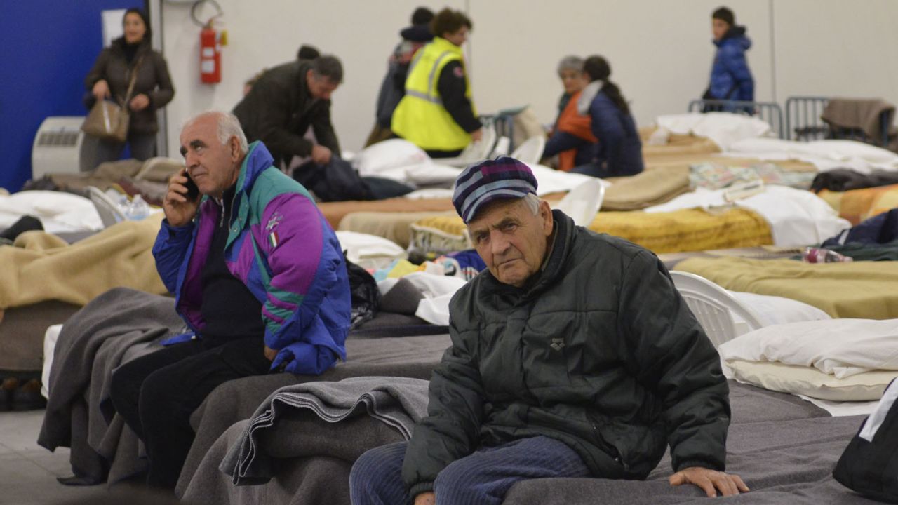 Residents prepare to spend the night in a camp set up in a warehouse in the village of Caldarola on Sunday following the quake.