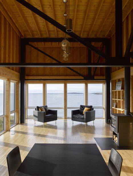 MacKay-Lyons Sweetapple Architects' graceful design includes a south-facing deck, wood and metal interiors, and floor-to-ceiling windows that overlook the sea. 