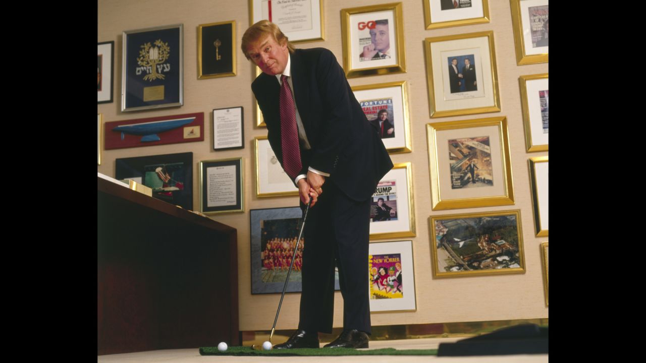 Trump putts a golf ball in his New York office in 1998.