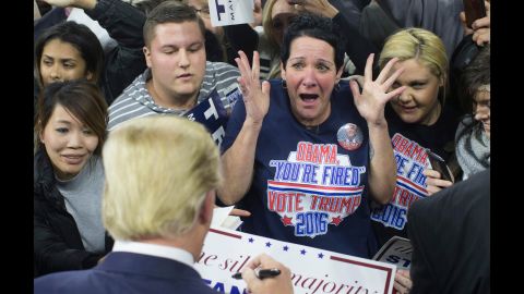 A supporter reacts as Trump signs her poster during a campaign rally in Lowell, Massachusetts, on January 4, 2016.