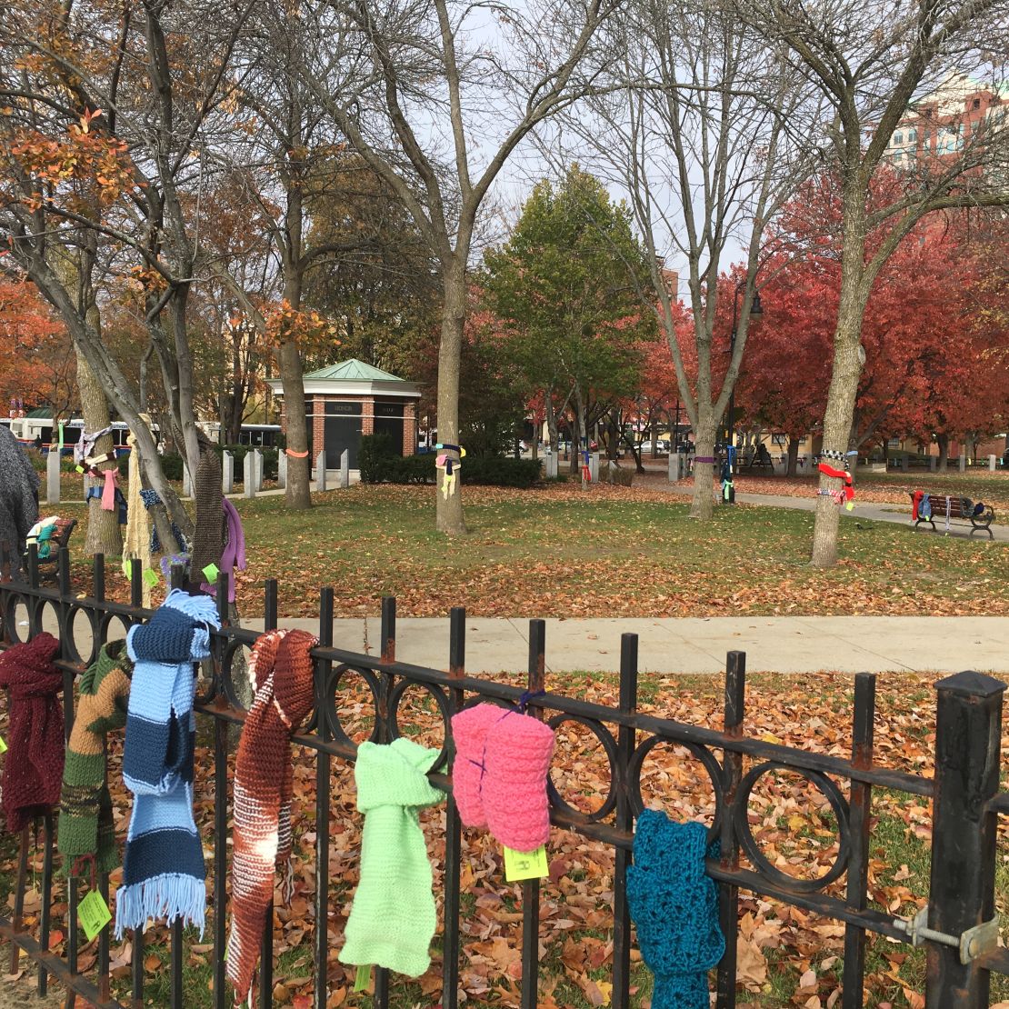 The brightly colored scarves and mittens adorn Veterans Memorial Park in Manchester.