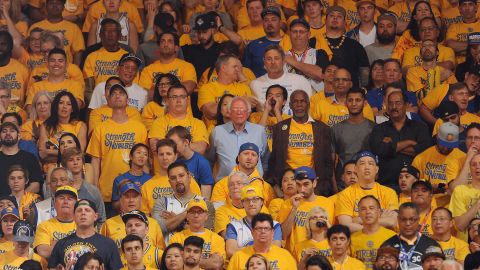 Sanders, at center in the light-blue shirt, watches a playoff basketball game in Oakland, California, on May 30, 2016. The candidate, campaigning for the state's primary, saw the Golden State Warriors win Game 7 of the NBA's Western Conference Finals.
