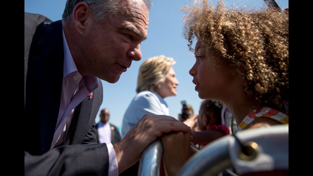 Kaine greets a child as he and Clinton arrive at an airport in Cleveland on September 5, 2016.
