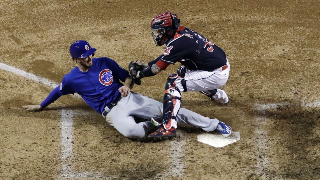 Kris Bryant of the Cubs slides safely under Indians catcher Roberto Perez during the fourth inning of Game 7.