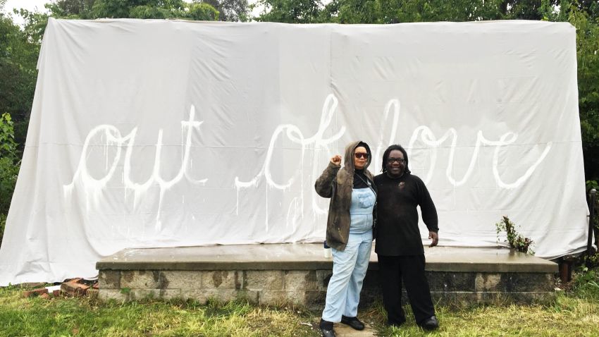 Rosa Parks' niece in front of the covered remains of the house in Detroit.