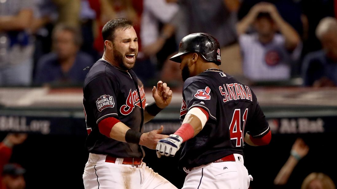 Jason Kipnis  and Carlos Santana of the Cleveland Indians celebrate after scoring runs on a wild pitch during the fifth inning in Game 7.