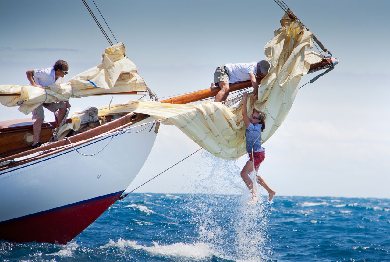 The bow woman of the yacht Gipsy loses her balance following a wave but is able to climb back on board thanks to a crew member during the Puig Vela Classica Barcelona. Luis Fernandez captured the action.