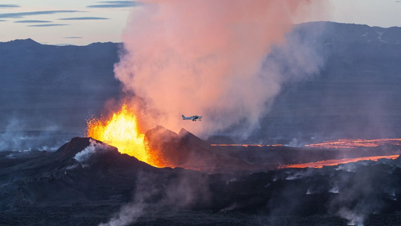 An aerial picture taken on September 14, 2014 shows a plane flying over the Bardarbunga volcano spewing lava and smoke in southeast Iceland. 
