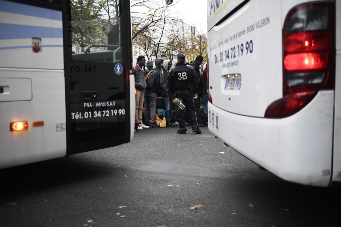 Police evacuate migrants Friday from a makeshift camp outside the Stalingrad metro station in Paris.