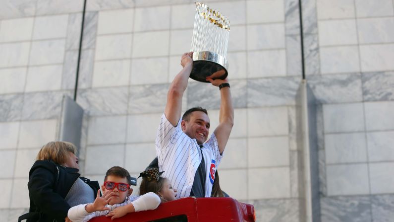 Cubs catcher Miguel Montero hoists the championship trophy during the parade.
