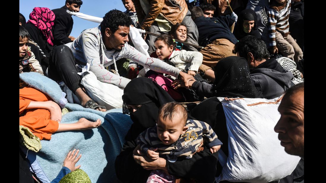 Iraqi families pack into a truck to be moved to camps on Thursday, November 3.