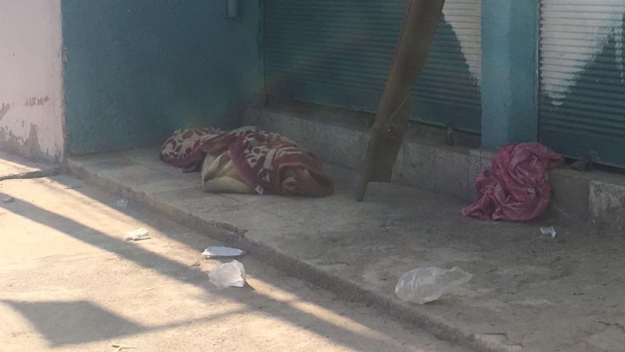 The body of the man who had been driving the taxi is wrapped in a pink floral blanket.