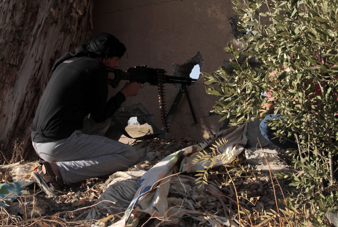 An opposition fighter holds position in clashes with government forces in the rebel-held Syrian city of Raqqa.
