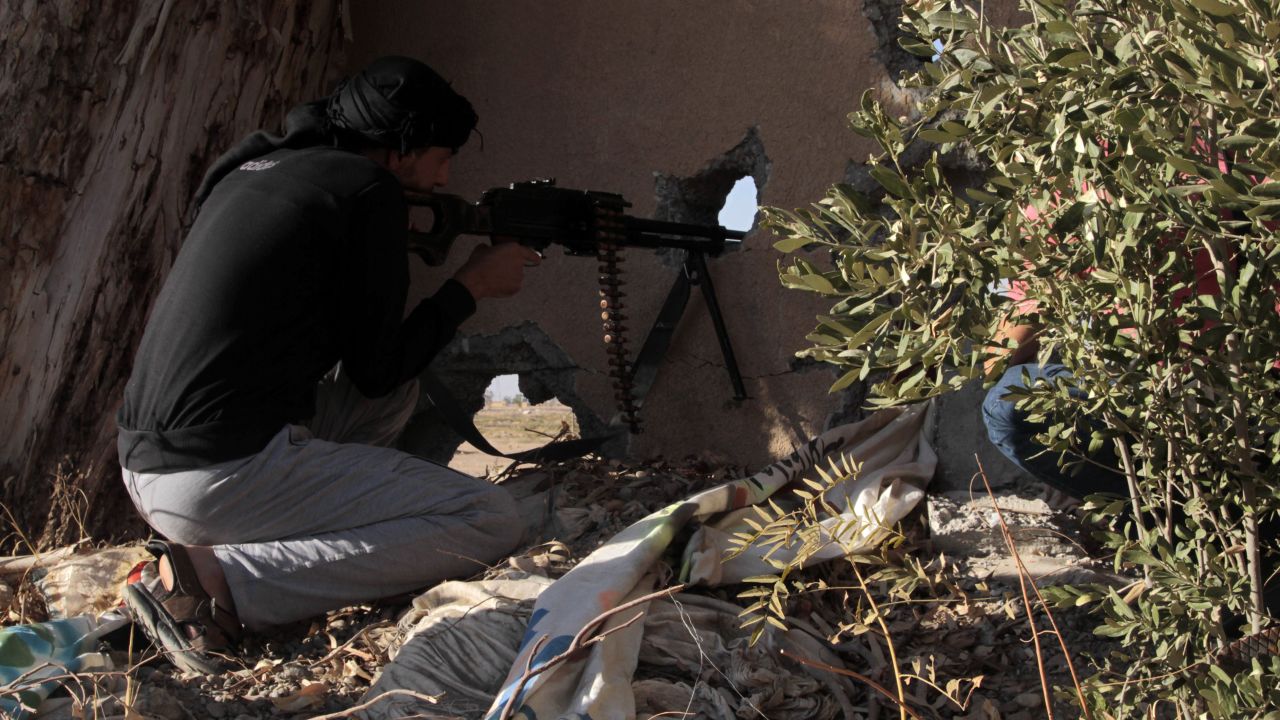 An opposition fighter holds position in clashes with government forces in the rebel-held Syrian city of Raqqa.