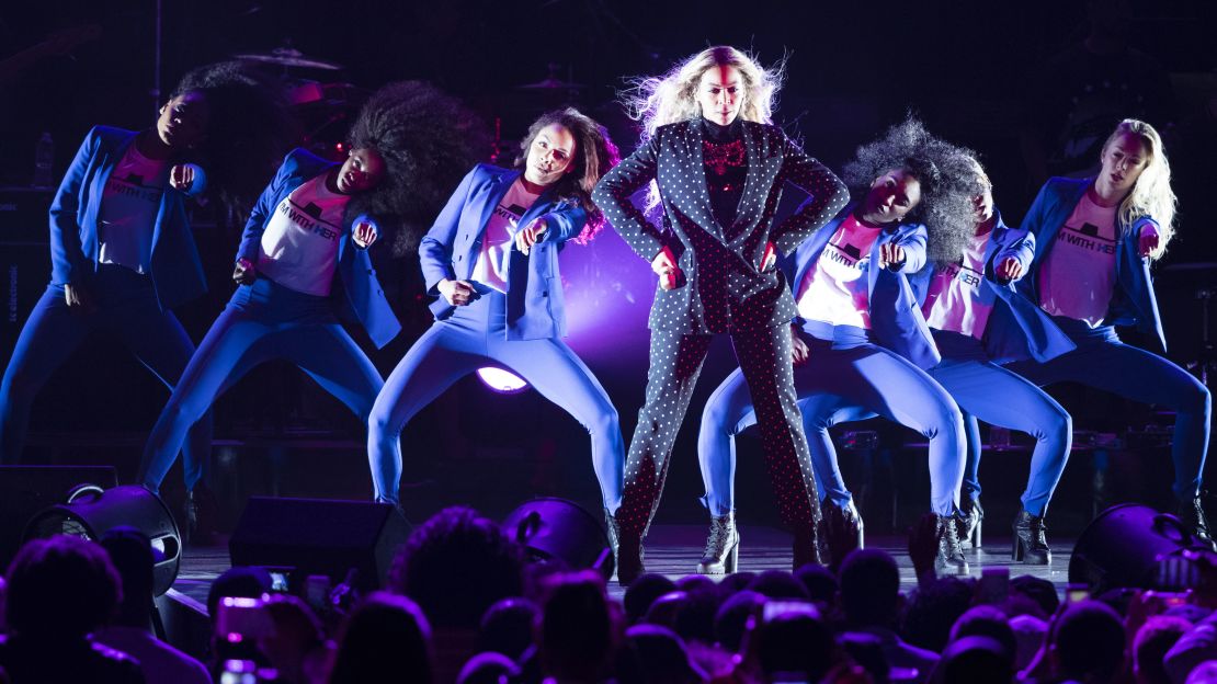 Beyonce and her dancers adopt Hillary Clinton's signature pantsuit at a campaign rally on November 4.