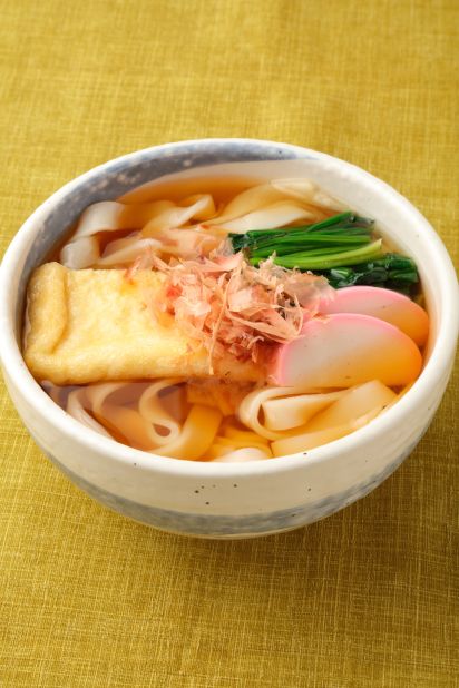 Kishimen are broad, flat noodles served with a broth that features a touch of sweet sake seasoning. Dried bonito shavings are tossed on the dish before serving.