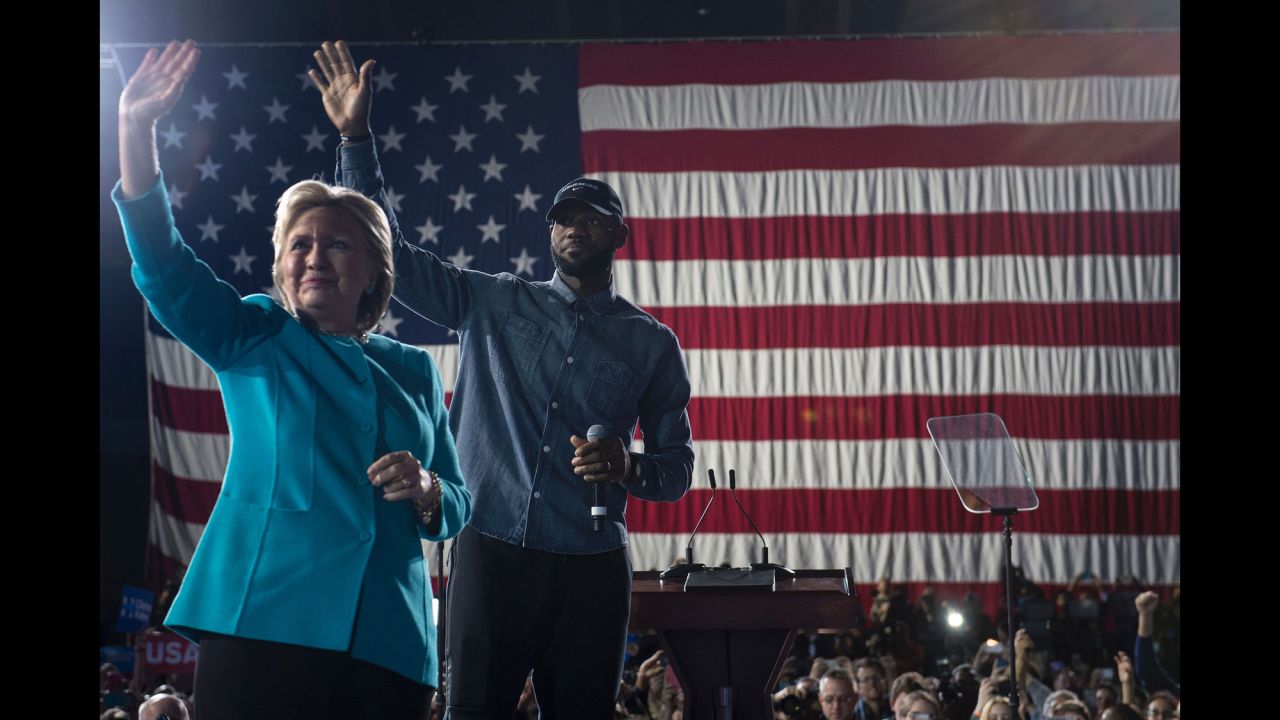 Clinton and NBA basketball player LeBron James wave to a crowd in Cleveland on November 6.